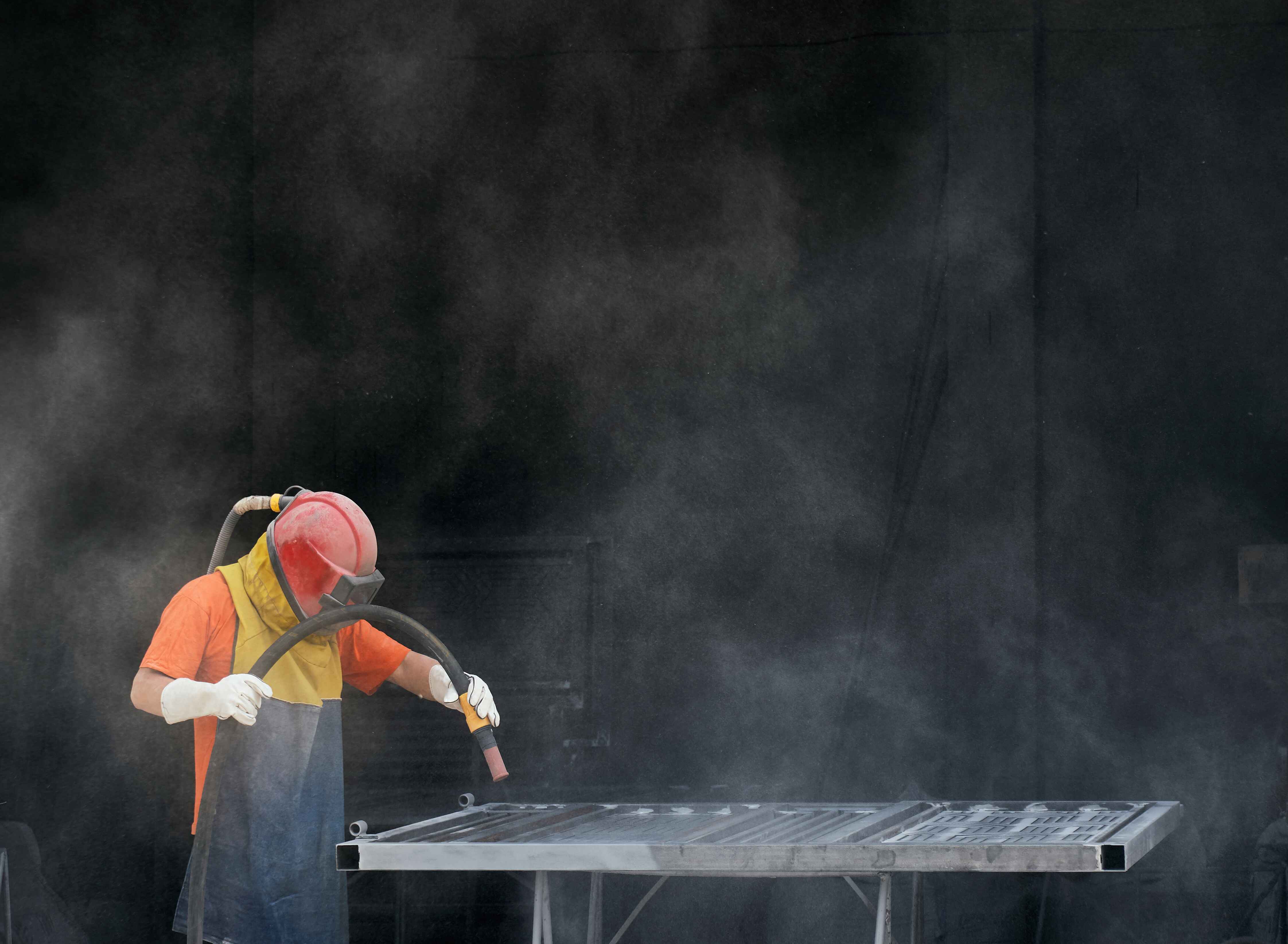 worker-in-protection-suit-polishing-fence